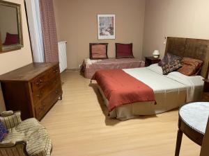 a bedroom with two beds and a dresser and a dresser at Le Rockastel in Le Caylar