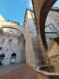 un grand bâtiment en briques avec une arche devant lui dans l'établissement Casa Delle Volte Perugia, à Pérouse