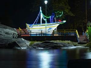 um barco numa ponte com luzes de Natal em Pousada Praia do Calixto em São Francisco do Sul