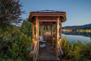 - un kiosque avec des chaises et des lumières sur un lac dans l'établissement Trails End Beach house suite w/hot tub, à Ladysmith