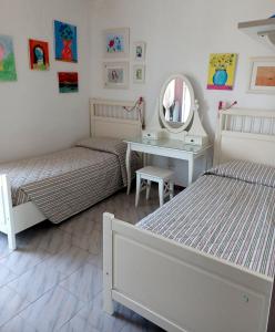 1 dormitorio con 2 camas, escritorio y espejo en LA TORRE DEL GABBIANO, en Pescara