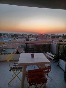 una mesa y sillas en un balcón con vistas a la puesta de sol en LA TORRE DEL GABBIANO, en Pescara