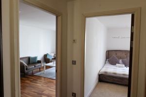 ein Wohnzimmer mit einem Bett und einem Spiegel in der Unterkunft Centrally located 1BR Apt near Edg Cricket, University of Bham, Priory Hospital & Cannon Hill Park in Birmingham