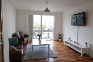 a living room with a couch and a table at Centrally located 1BR Apt near Edg Cricket, University of Bham, Priory Hospital & Cannon Hill Park in Birmingham