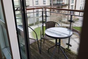 a table and two chairs on a balcony at Centrally located 1BR Apt near Edg Cricket, University of Bham, Priory Hospital & Cannon Hill Park in Birmingham