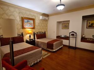 a hotel room with two beds and a lamp at Hotel Casa Divina Oaxaca in Oaxaca City