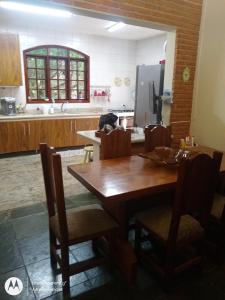 eine Küche mit einem Holztisch und Stühlen in der Unterkunft Chácara dos Pinheiros in São Roque
