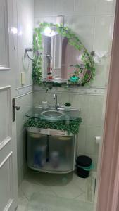y baño con lavabo y espejo. en Quarto individual, em apto compartilhado, en Belém