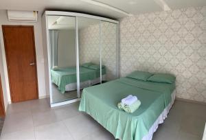 een slaapkamer met 2 bedden en een spiegel bij RB hospedagem in Cabo Frio