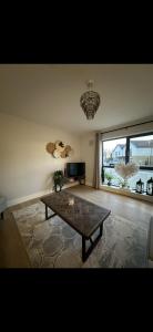 a living room with a coffee table and a large window at Home in Kilmuckridge in Wexford