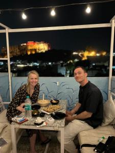 mężczyzna i kobieta siedzący przy stole z jedzeniem w obiekcie Shyam Hostel w mieście Dźodhpur