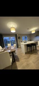eine Küche und ein Esszimmer mit einem Tisch und Stühlen in der Unterkunft Home in Kilmuckridge in Wexford