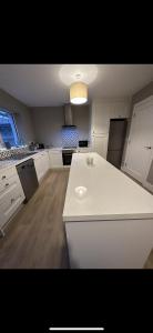 una cucina con piano di lavoro bianco in una camera di Home in Kilmuckridge a Wexford
