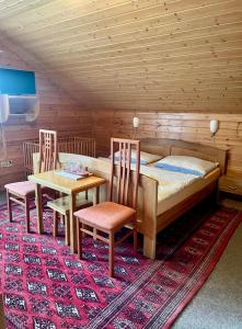 1 Schlafzimmer mit einem Bett, 2 Stühlen und einem Tisch in der Unterkunft Pension Grizzly in Ludvíkov