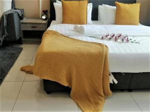uma cama grande com lençóis brancos e flores em Chambers PWTC By GrandRoyal em Kuala Lumpur