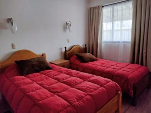 聖維森特德塔瓜塔瓜的住宿－Casa en el Corazón de San Vicente，一间带两张红色毯子的卧室