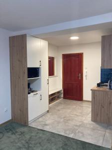 an empty room with a kitchen with a red door at METRO APARTMENT in Bielsko-Biała
