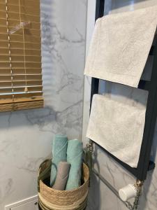 a basket of towels in a bathroom next to a mirror at METRO APARTMENT in Bielsko-Biała