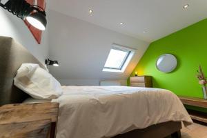 a bedroom with a bed with a green wall at Wit Peerd Guesthouse in Londerzeel