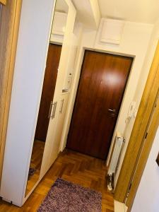 a hallway with a wooden door and a rug at Apartman Dobrinja 1 in Sarajevo