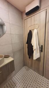 a bathroom with a door with a bed and a sink at Les Oliviers : Studio spacieux belle vue mer, Clim in Port-Vendres