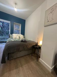 a bedroom with a bed with blue walls at Halloway Guest Studio 54 in London