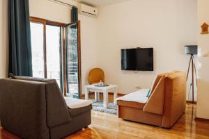 a living room with two chairs and a tv at Apartman Mia in Risan