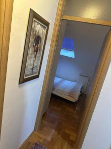a hallway with a mirror and a bed in a room at Apartman Dobrinja 1 in Sarajevo