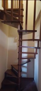 una scala a chiocciola in legno in una camera di Poggio Giulia a Montaione