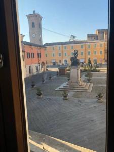 a view of a courtyard with a statue in front of a building at palazzo piazza centrale in Bagnacavallo