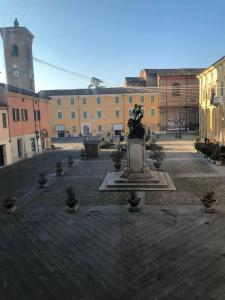 a courtyard with a statue in the middle of a building at palazzo piazza centrale in Bagnacavallo