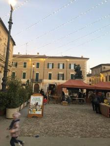 a child walking down a street next to a building at palazzo piazza centrale in Bagnacavallo