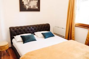 a bedroom with a bed with blue pillows on it at Apartman Mia in Risan