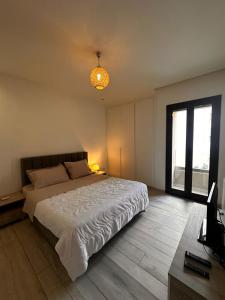 a bedroom with a large bed and a window at Joli S2 a la Marsa in La Marsa