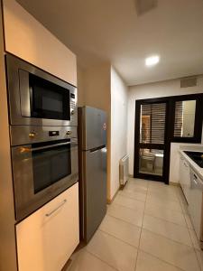 a kitchen with a stainless steel refrigerator and a microwave at Joli S2 a la Marsa in La Marsa
