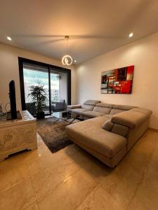 a large living room with a couch and a tv at Joli S2 a la Marsa in La Marsa