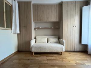 een woonkamer met een stoel en een kast bij Appartement à 10mn de Paris - PUTEAUX in Puteaux
