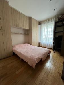 ein Schlafzimmer mit einem Bett in einem Zimmer mit einem Fenster in der Unterkunft Appartement à 10mn de Paris - PUTEAUX in Puteaux
