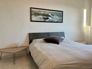 1 dormitorio con cama y mesa en la pared en LMHouse, en Arma di Taggia