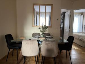 een eetkamer met een glazen tafel en stoelen bij Appartement à 10mn de Paris - PUTEAUX in Puteaux
