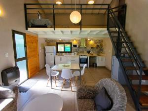 uma cozinha com uma mesa e cadeiras e uma escadaria em Loft Chacras em Chacras de Coria