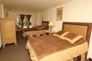 a hotel room with two beds and a chair at Hotel Martell in San Pedro Sula
