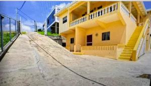 a yellow house with a ramp leading up to it at Patrickville in Gwa Kay