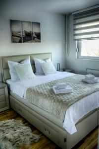 um quarto com uma grande cama branca e uma janela em Irina Lux Apartment em Negotin