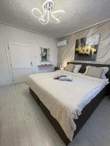 a bedroom with a large white bed with a chandelier at Alia house with garden in Piešťany in Piešťany