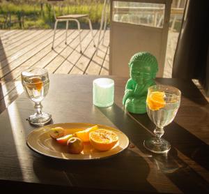 una figurita verde sentada en una mesa con un plato de naranjas en Uy - Cabaña de ESTILO, entorno Natural ùnico, en Mercedes