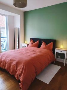 a bedroom with a red bed with a green wall at Appartement spacieux in Charmes
