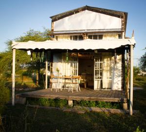 Casa con porche con mesa y sillas en Uy - Cabaña de ESTILO, entorno Natural ùnico, en Mercedes