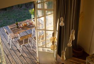 a sliding glass door leading to a table on a deck at Uy - Cabaña de ESTILO, entorno Natural ùnico in Mercedes +38 photos