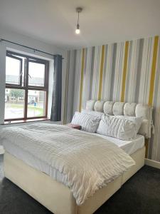 una camera da letto con un grande letto bianco e una finestra di The Comfy place Shared a Dallington